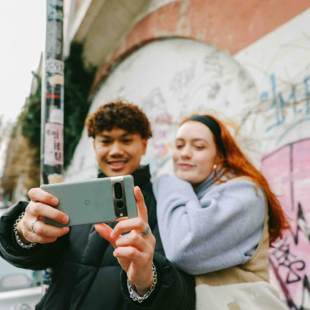 Zwei Jugendliche schauen auf Handy